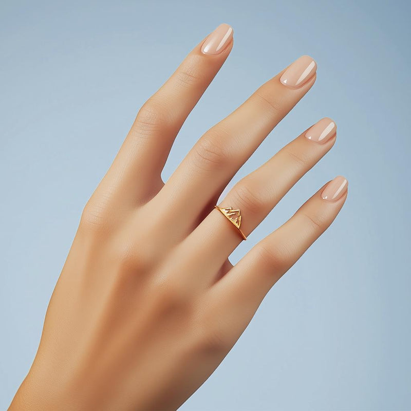 Thin gold stacking ring with a small flat mountain peak across the top, on a hand (8 of 9)