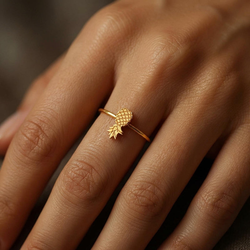Thin gold ring with a small pineapple sitting on the crown of the band. (4 of 8)