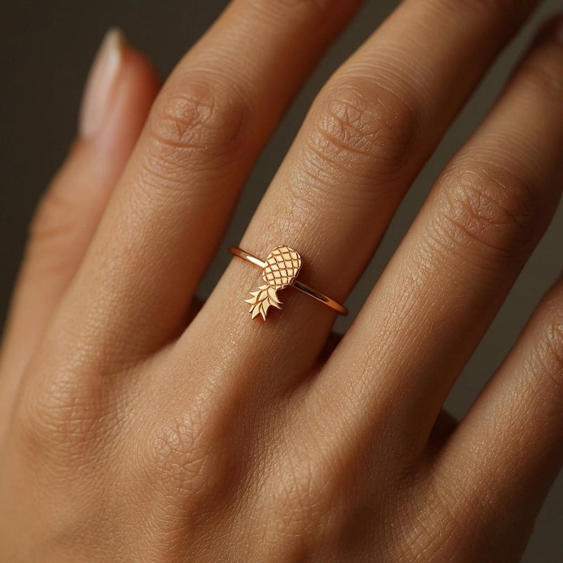 Thin gold ring with a small pineapple sitting on the crown of the band. (6 of 8)