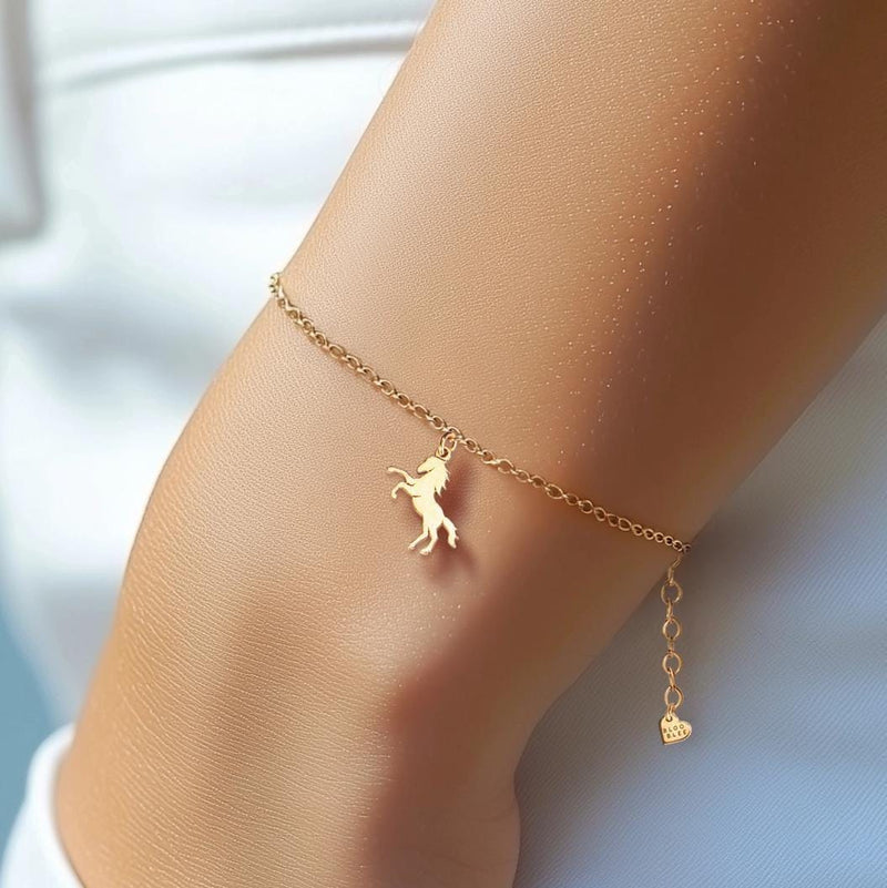 Fine gold chain bracelet with a tiny horse charm and lobster clasp on a wrist (10 of 11)