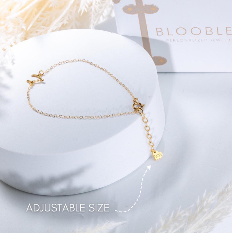 Fine gold chain bracelet with a tiny horse charm and lobster clasp on a wrist (8 of 11)