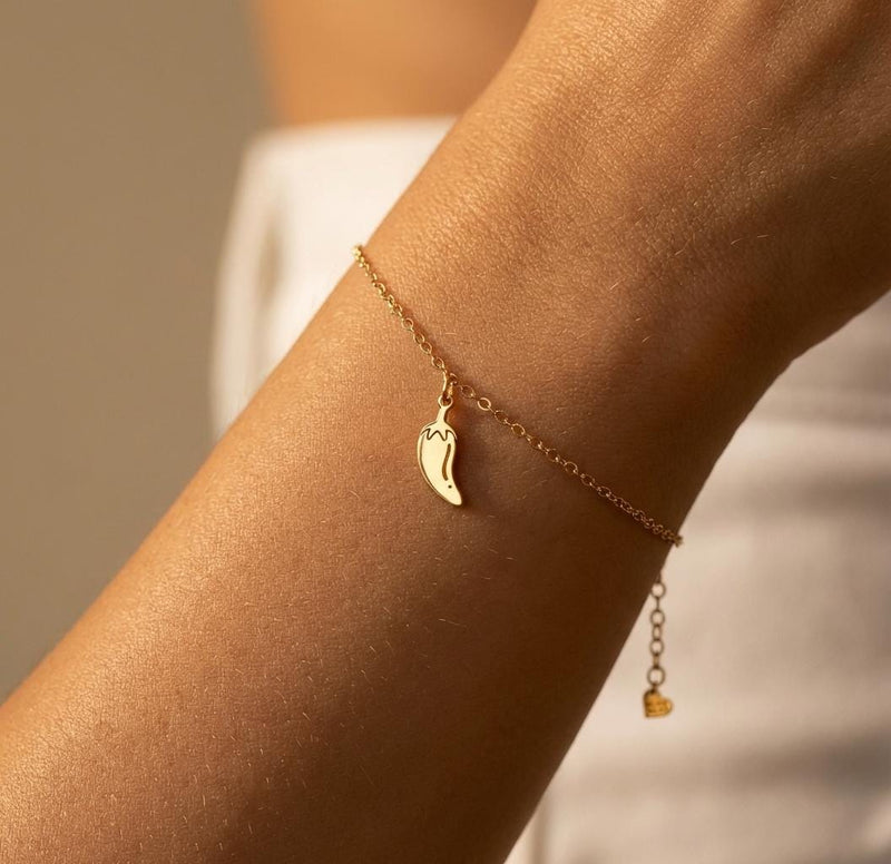 Tiny gold chili pepper charm with curved body and hooked stem on a chain bracelet (5 of 12)