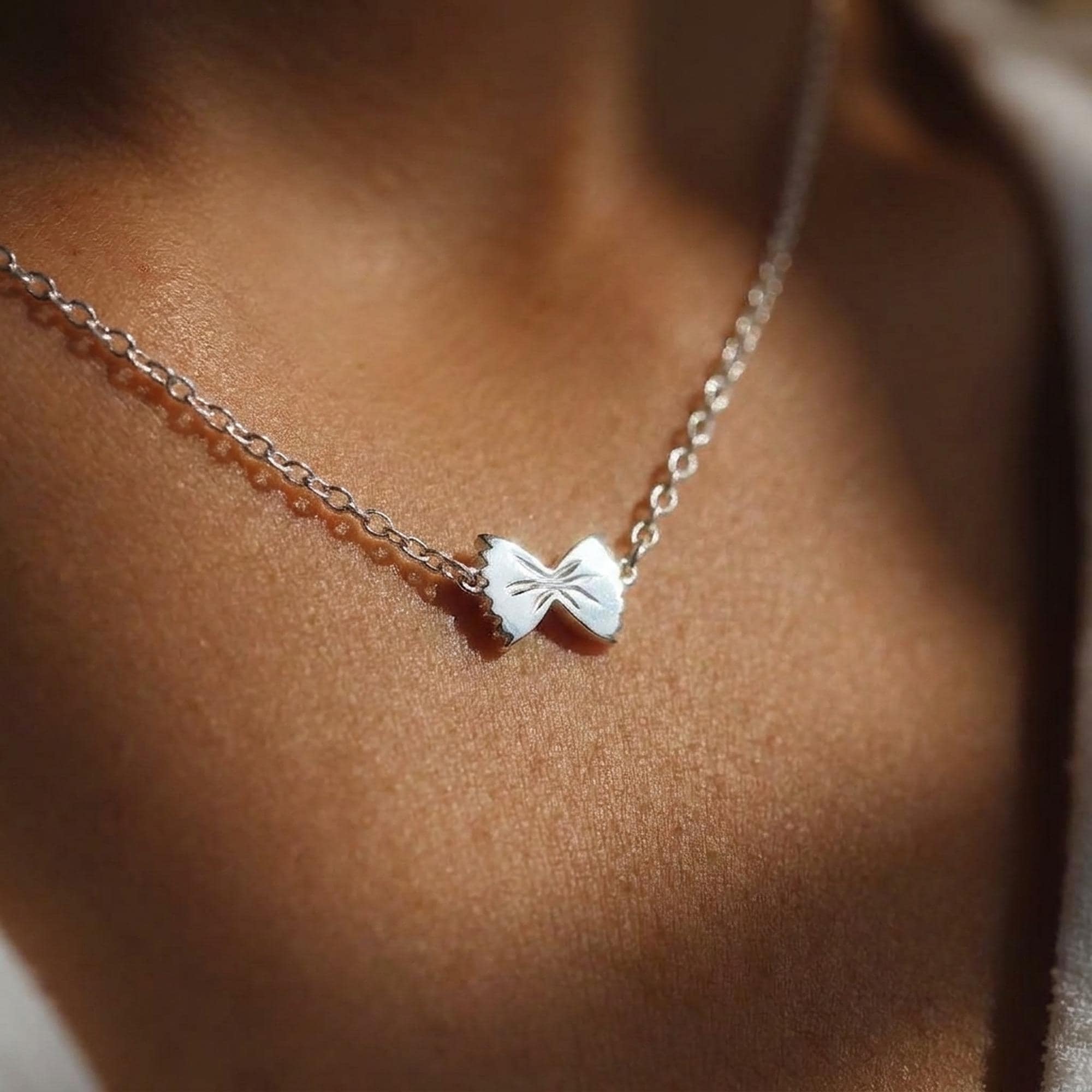 Tiny gold pasta charm pendant on a fine cable chain, photographed flat. (2 of 10)