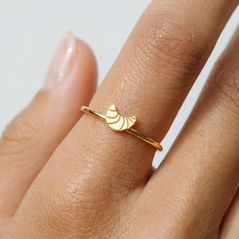 Slim gold stacking ring topped with a small layered croissant