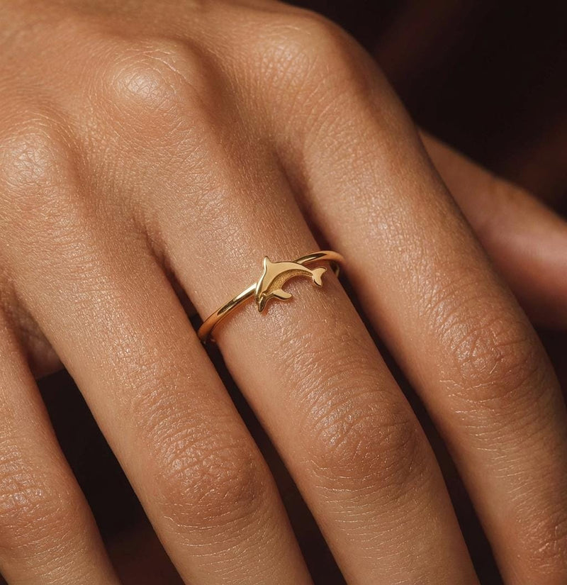 Thin gold ring with a small sculpted dolphin arcing across the top (2 of 9)