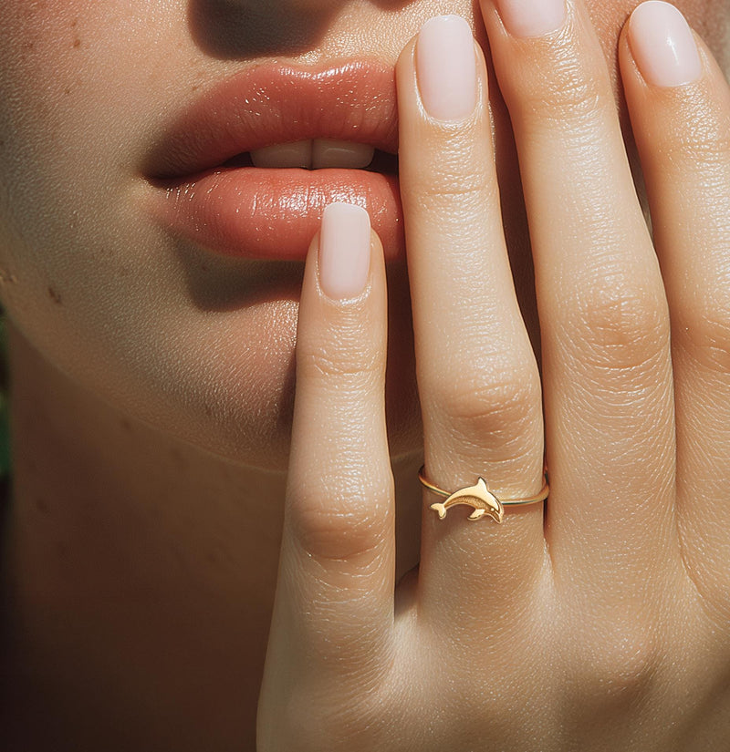 Thin gold ring with a small sculpted dolphin arcing across the top (3 of 9)