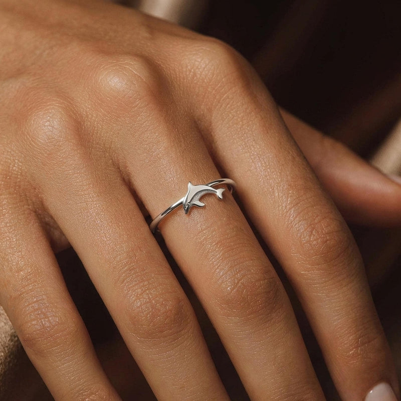 Thin gold ring with a small sculpted dolphin arcing across the top (9 of 9)