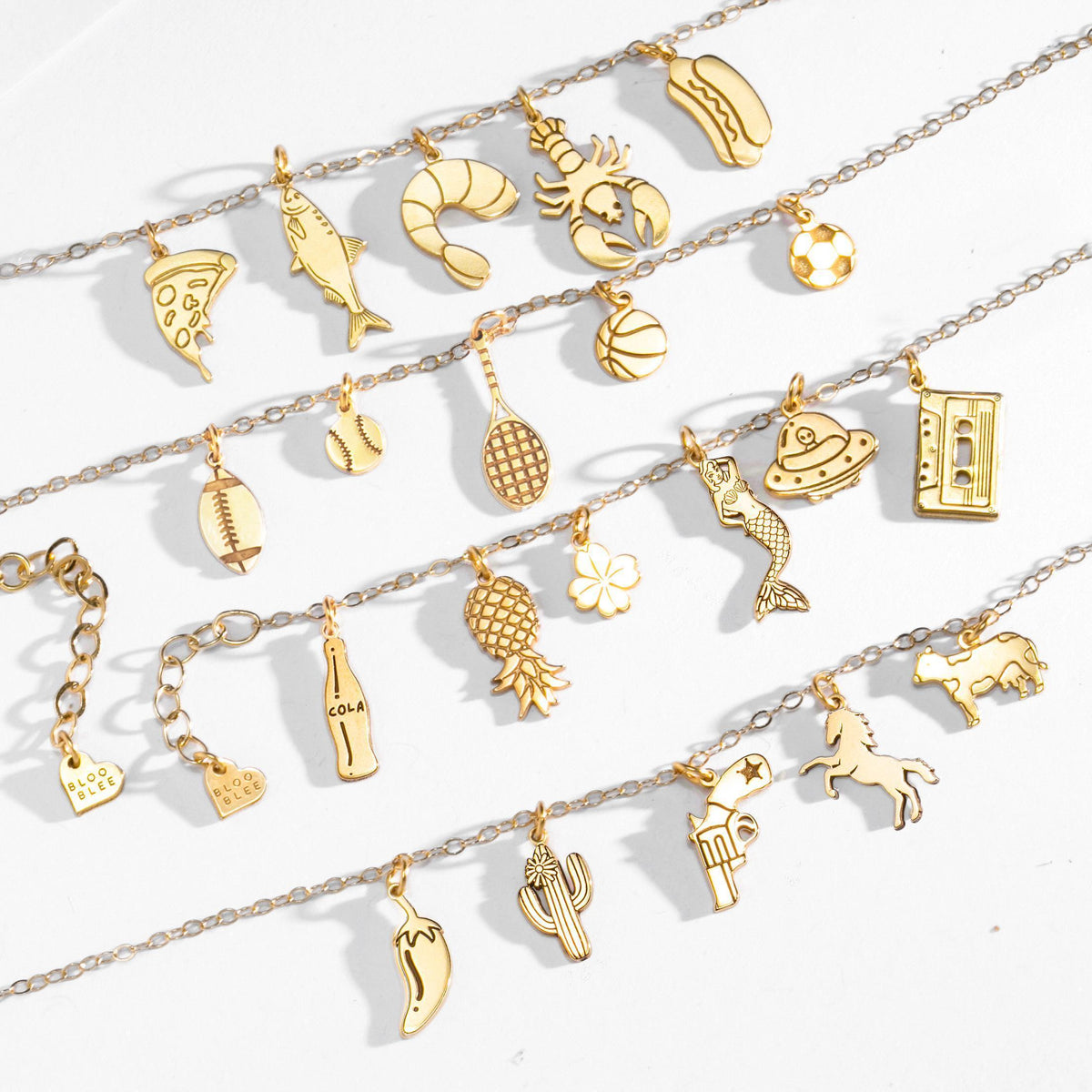 Fine gold chain anklet hung with several small gold charms and a clasp