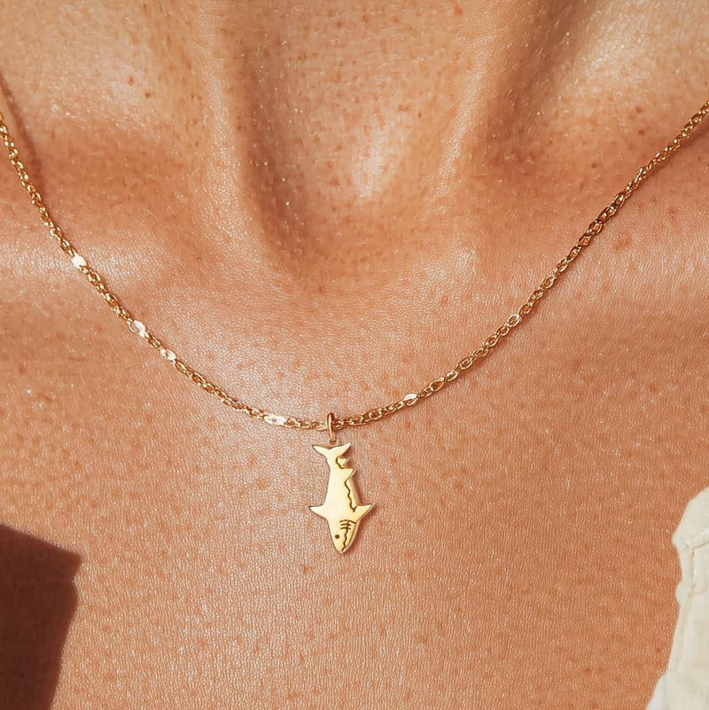 Fine gold chain necklace with a small shark pendant shown in profile (2 of 9)