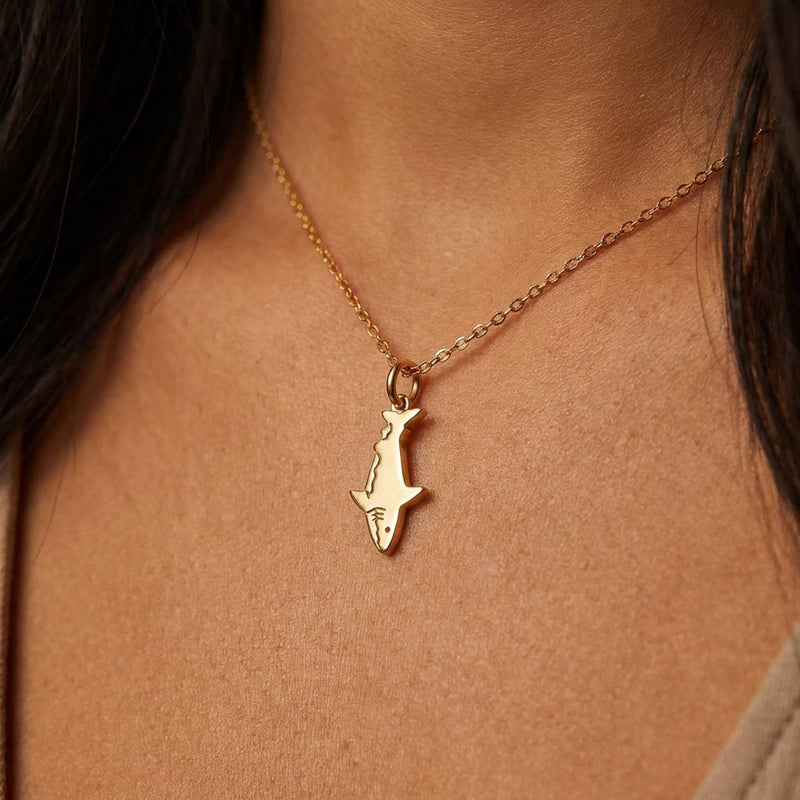 Fine gold chain necklace with a small shark pendant shown in profile (7 of 9)