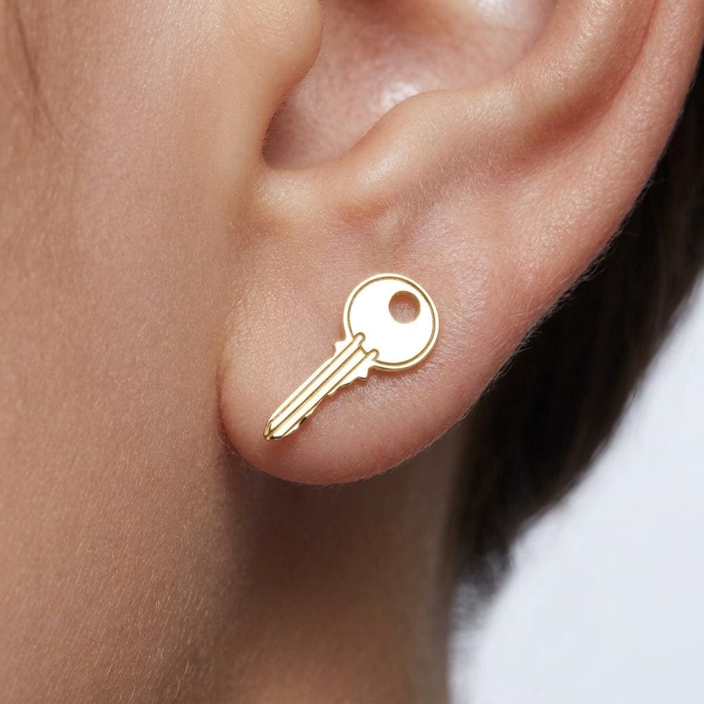 Pair of narrow old fashioned house key stud earrings in gold