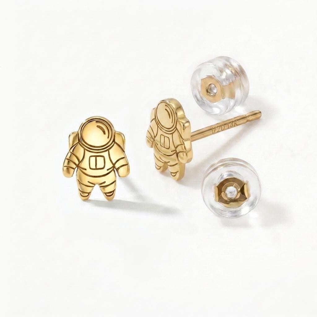 Pair of small gold astronaut stud earrings shown front on