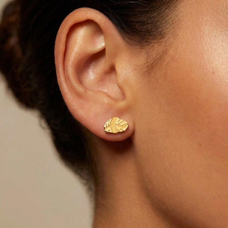 Pair of gold nigiri sushi stud earrings with rice base and fish slice on top