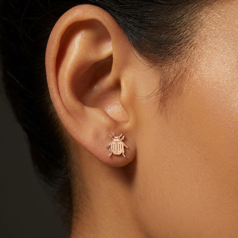 Pair of gold scarab beetle stud earrings seen from above. (6 of 9)