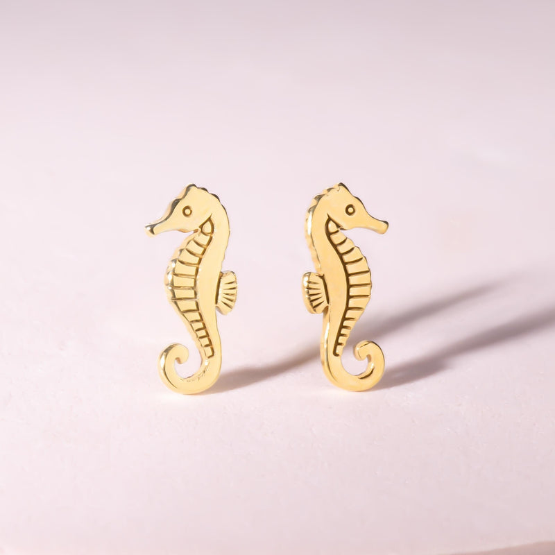 Pair of small gold seahorse stud earrings with curled tails. (2 of 8)