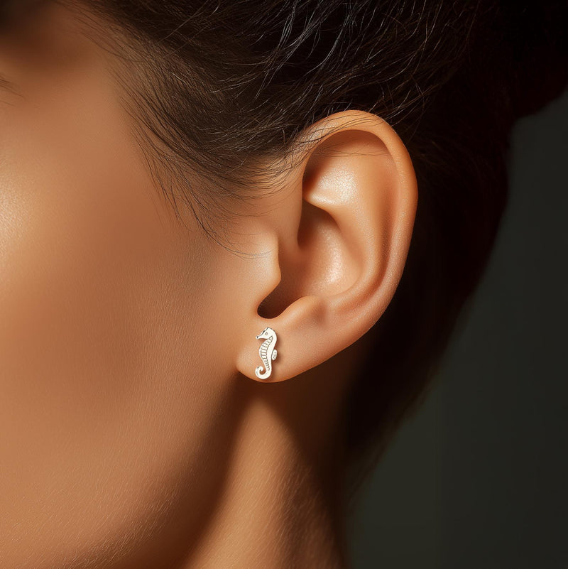 Pair of small gold seahorse stud earrings with curled tails. (3 of 8)