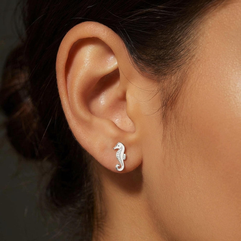 Pair of small gold seahorse stud earrings with curled tails. (8 of 8)