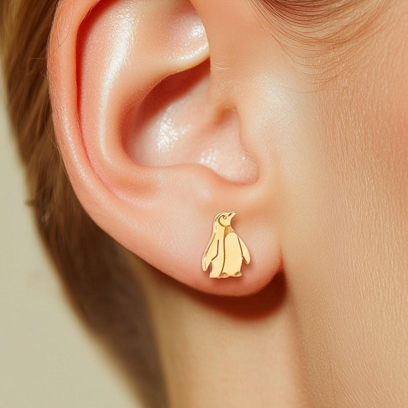 Pair of small gold penguin stud earrings with short flippers and a belly panel. (11 of 12)
