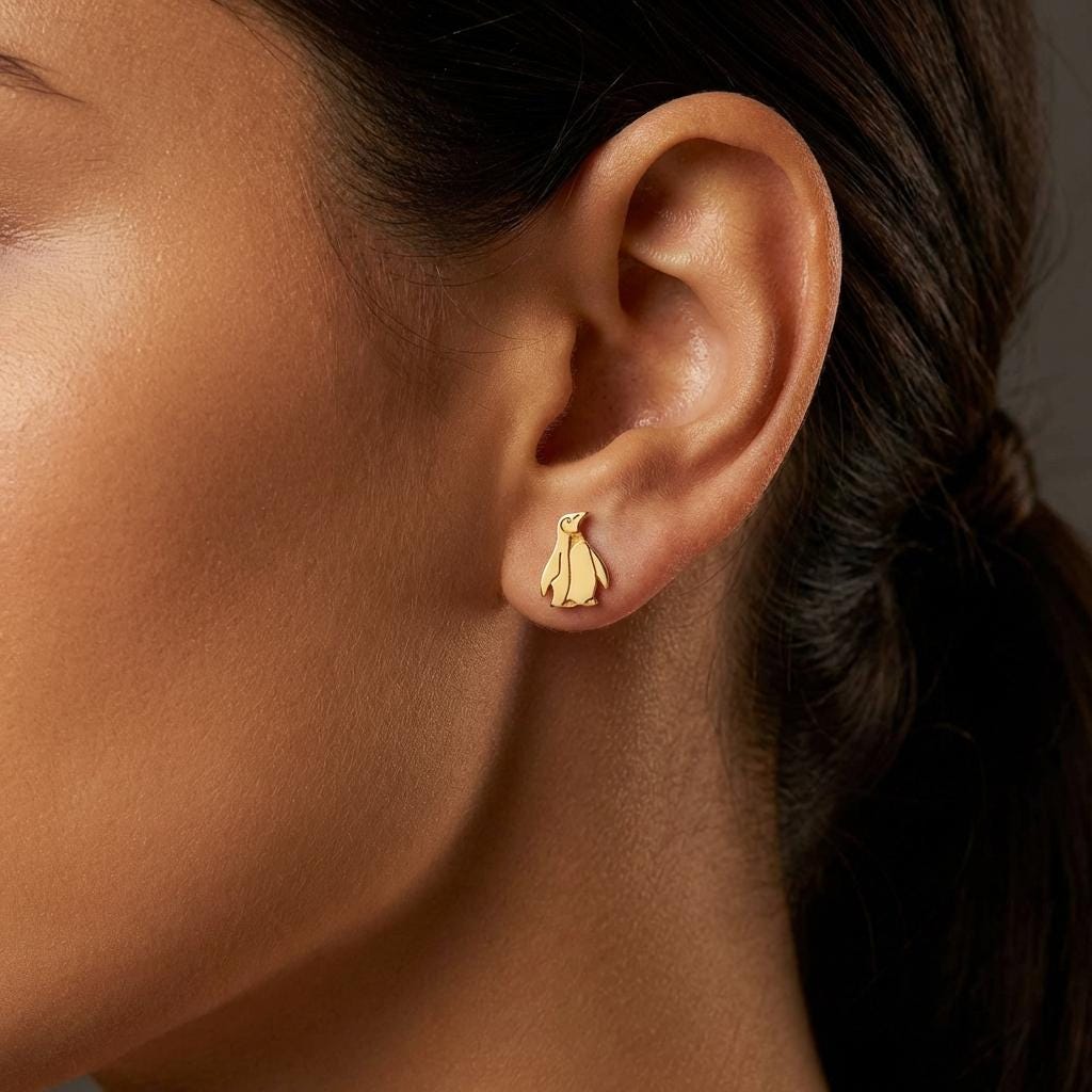 Pair of small gold penguin stud earrings with short flippers and a belly panel. (2 of 12)