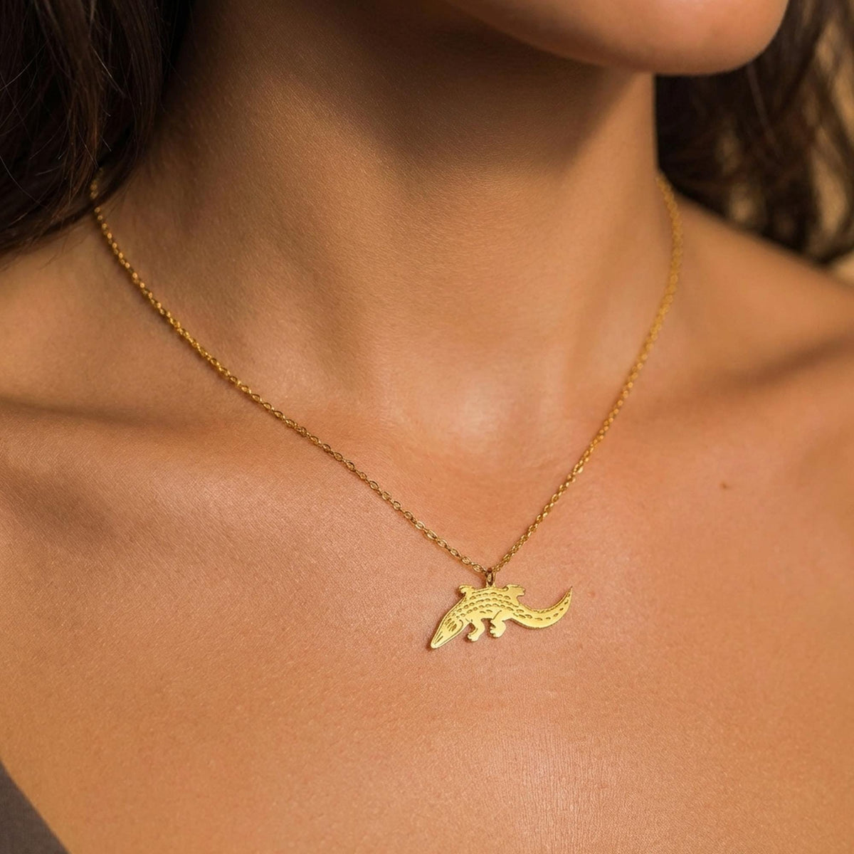 Fine gold necklace with a small flat alligator pendant