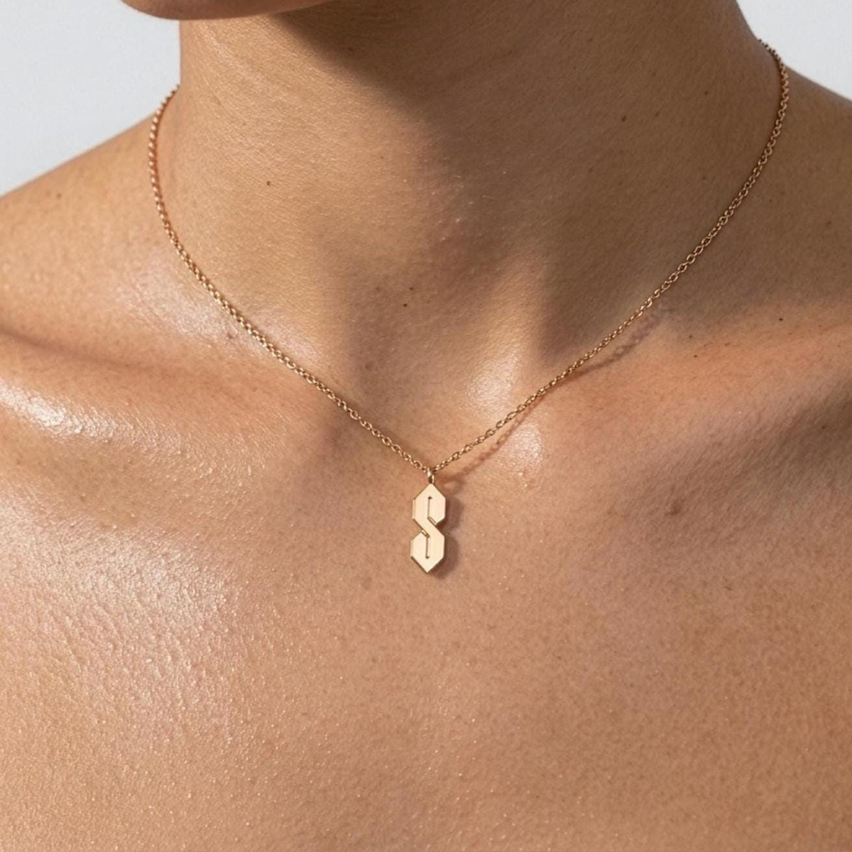 Fine gold chain necklace with an angular geometric S shaped pendant