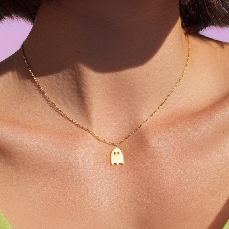Tiny gold ghost pendant on a fine cable chain, shown flat (2 of 8)