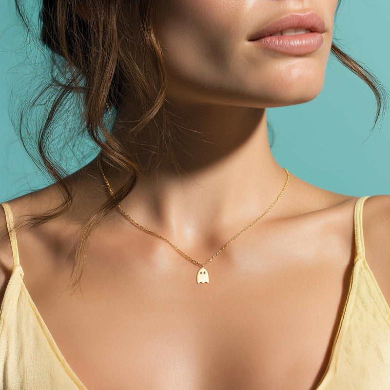 Tiny gold ghost pendant on a fine cable chain, shown flat (5 of 8)