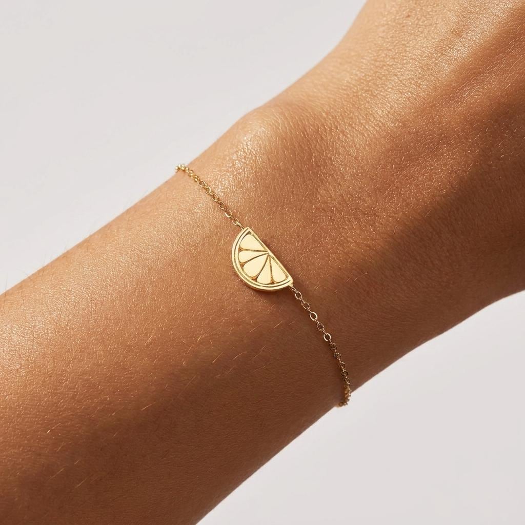 Fine chain bracelet with a small gold lemon slice charm