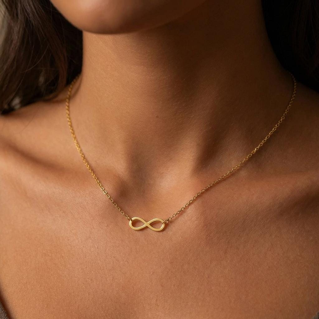 Small gold infinity loop pendant lying flat on a fine cable chain (2 of 10)
