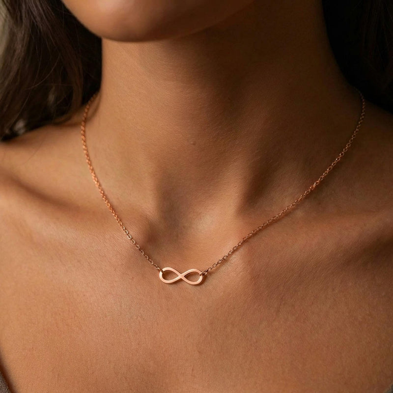 Small gold infinity loop pendant lying flat on a fine cable chain (3 of 10)