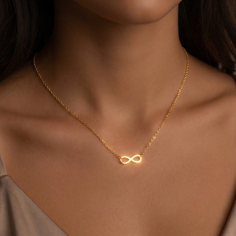 Small gold infinity loop pendant lying flat on a fine cable chain (6 of 10)
