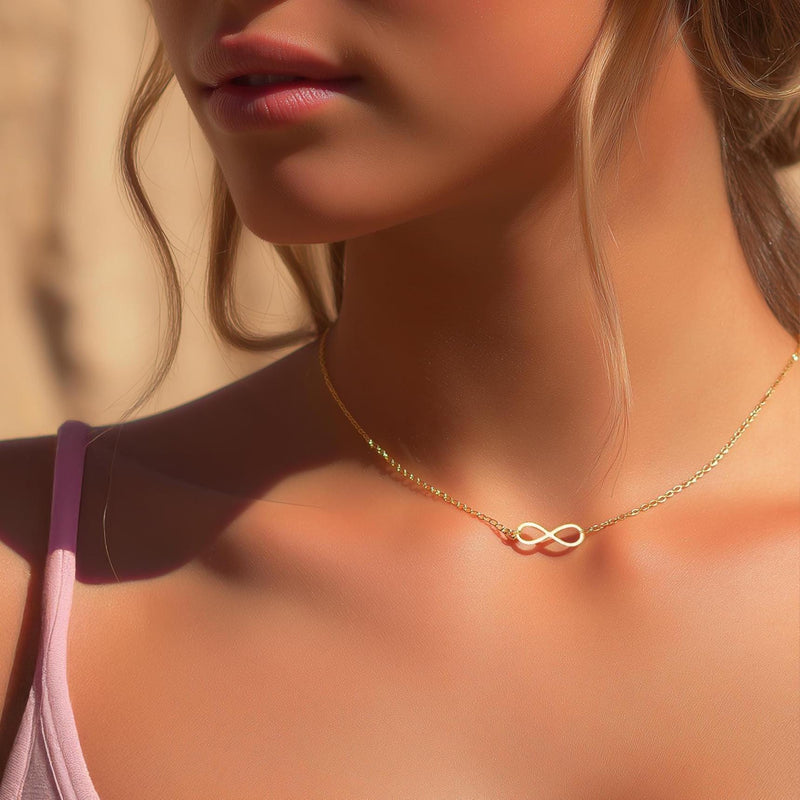 Small gold infinity loop pendant lying flat on a fine cable chain (7 of 10)