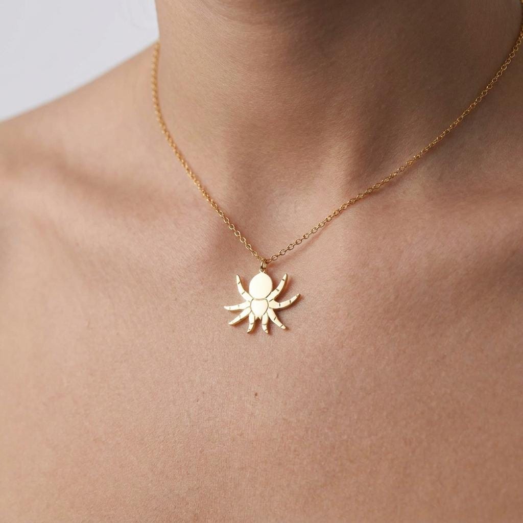 Short gold chain choker with a tiny tarantula charm sitting at the front