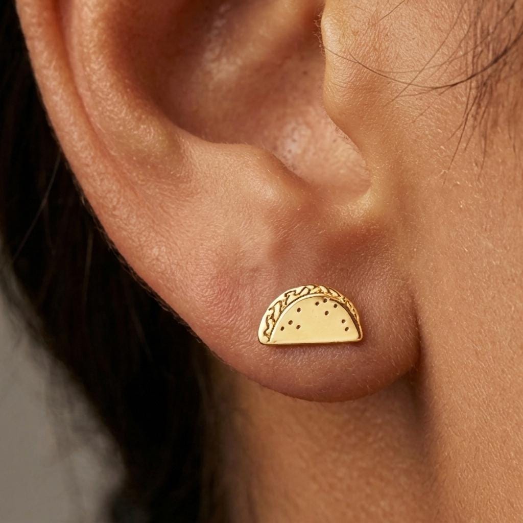 Small gold taco stud earrings, folded shell silhouette, shown as a pair