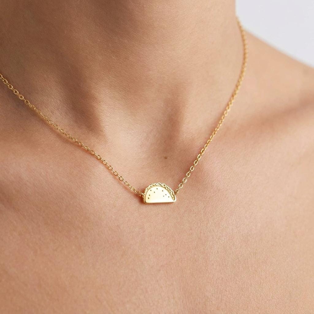 Tiny gold taco pendant on a fine cable chain, shown flat