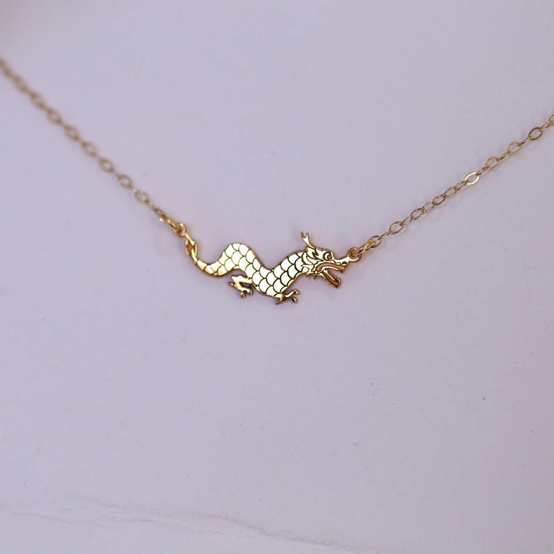 Fine gold chain bracelet with a small dragon charm in profile (4 of 7)