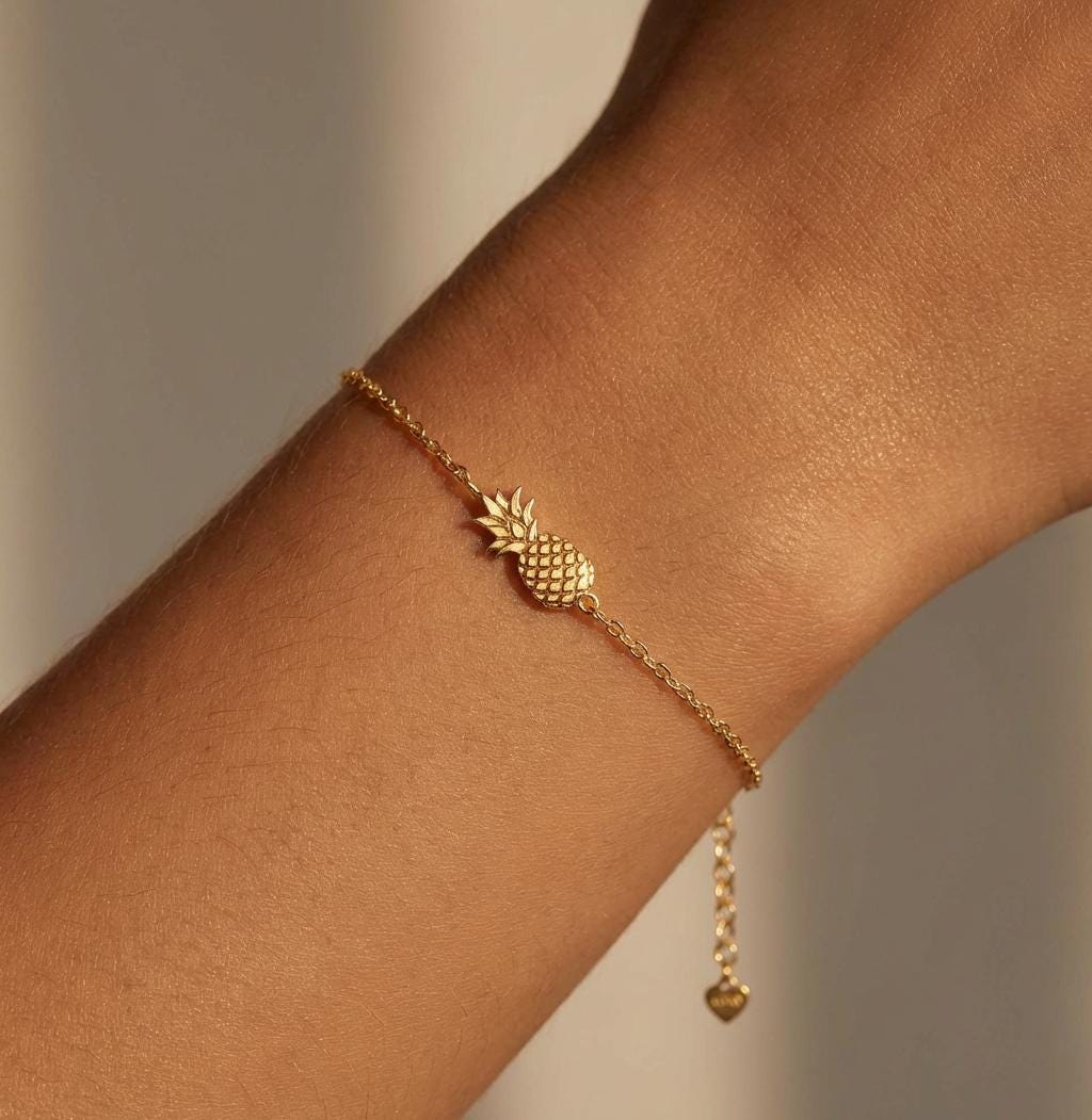 Fine chain bracelet with a small textured pineapple charm in gold
