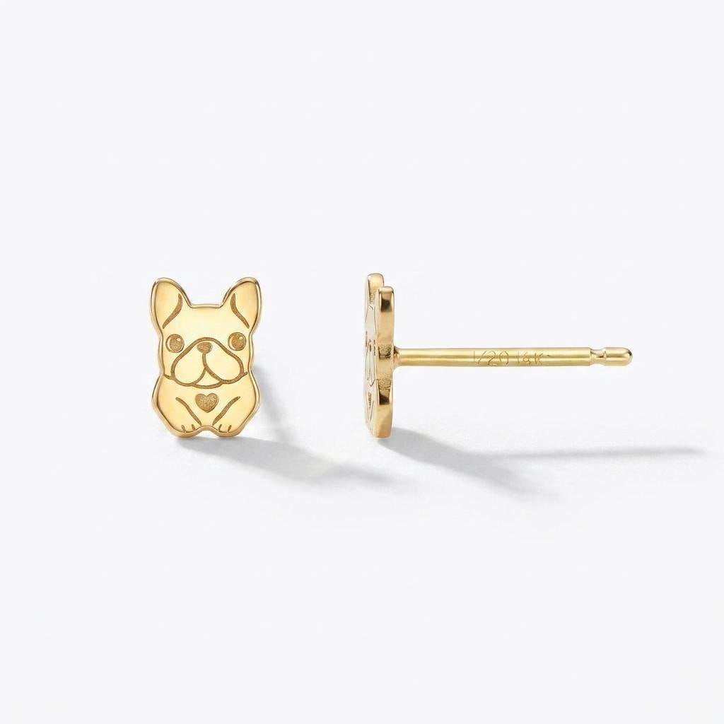 Pair of tiny gold french bulldog stud earrings with bat ears, on white