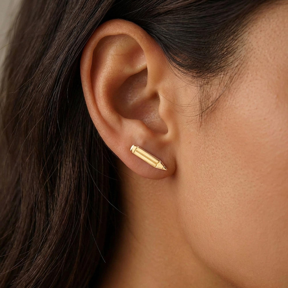 Pair of long thin gold pencil stud earrings with point and eraser detail