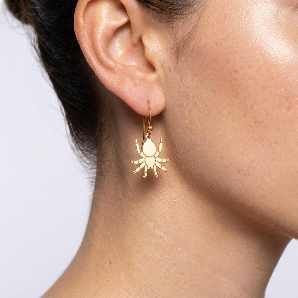Pair of gold tarantula earrings hanging from short posts, legs spread.