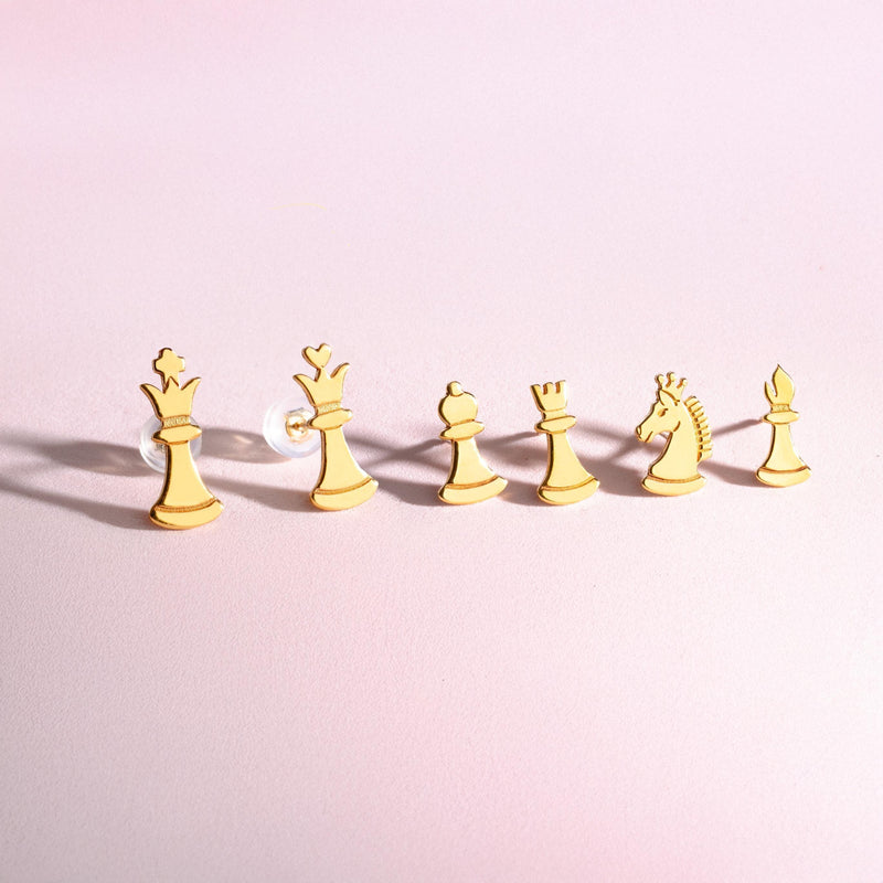 Set of gold chess piece stud earrings including knight, king and pawn, white background. (6 of 9)