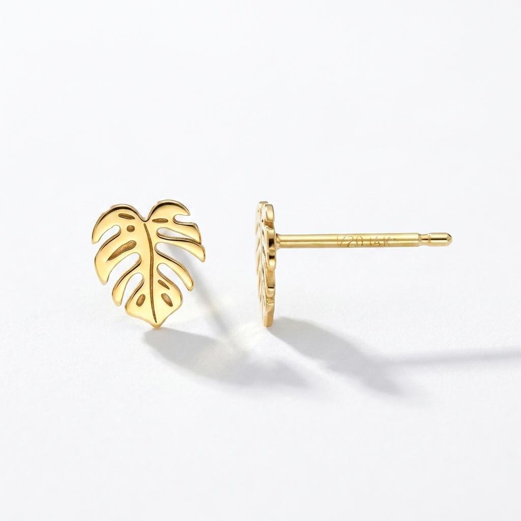 Tiny gold monstera leaf stud earrings with split leaf detail