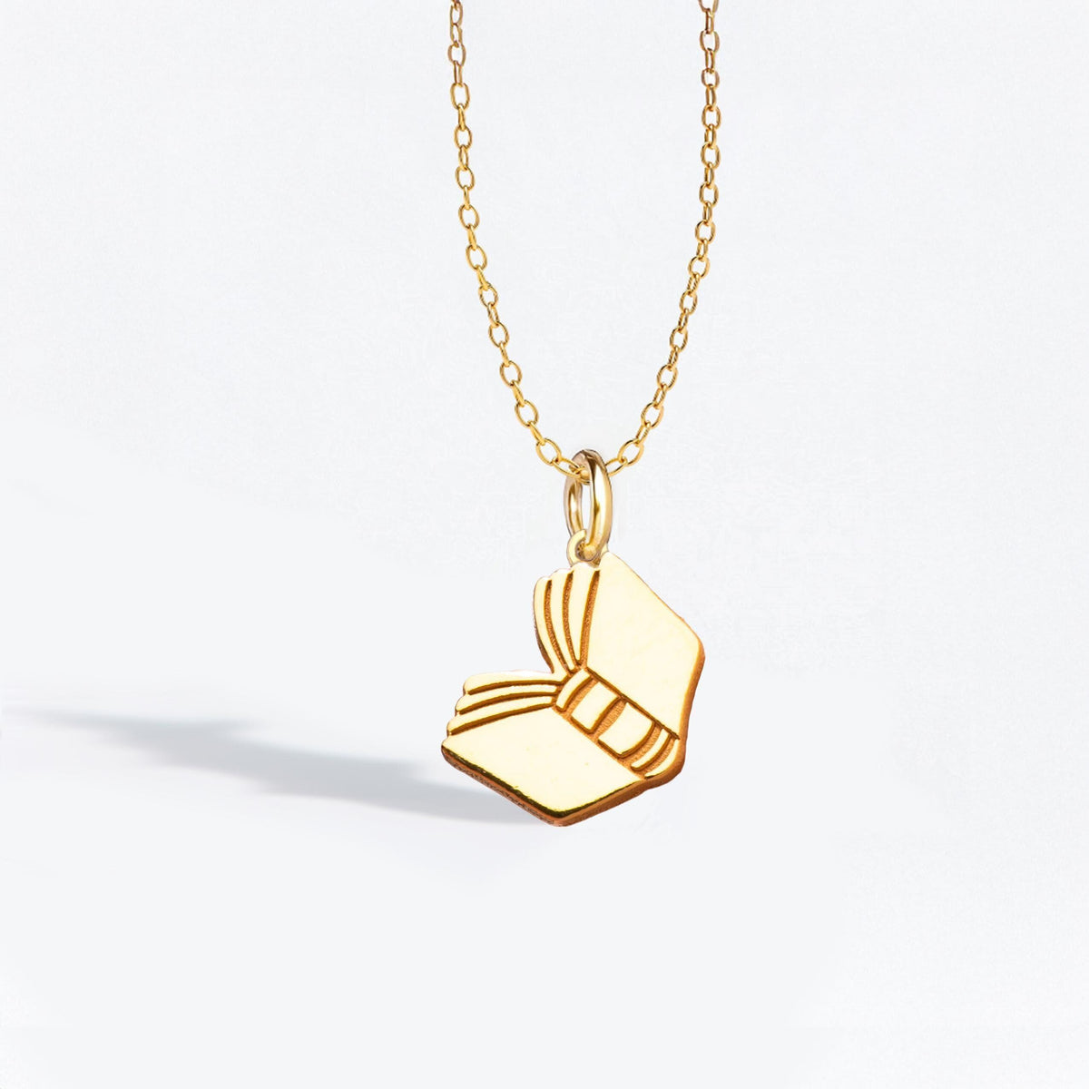 Dainty gold open book pendant with splayed pages on a fine chain