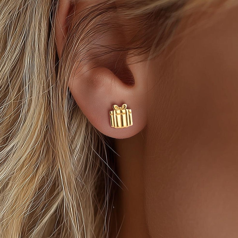 Pair of tiny gold present stud earrings with a ribbon across the front and a bow on top