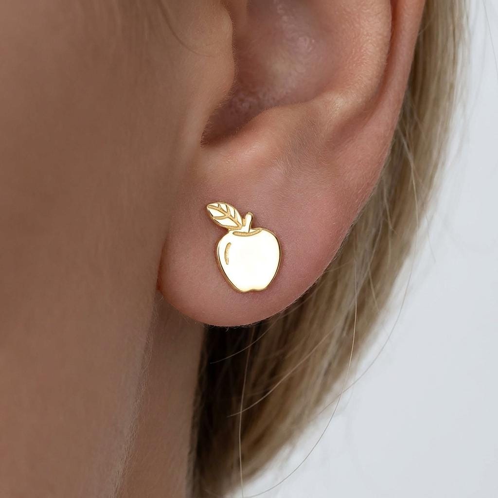 Pair of tiny gold apple stud earrings with stem and leaf, shown on white (2 of 10)