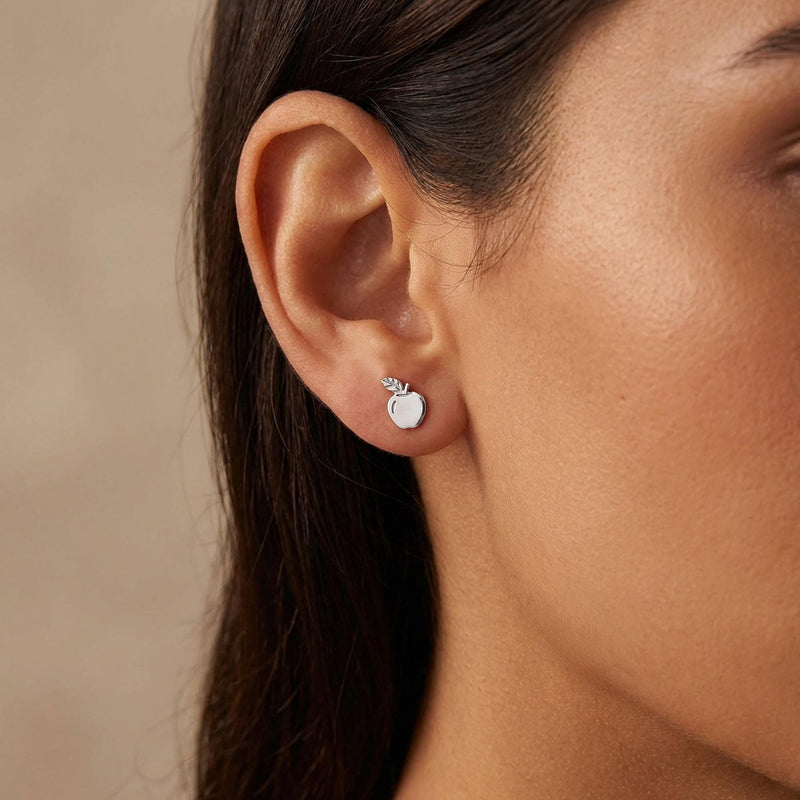 Pair of tiny gold apple stud earrings with stem and leaf, shown on white (3 of 10)