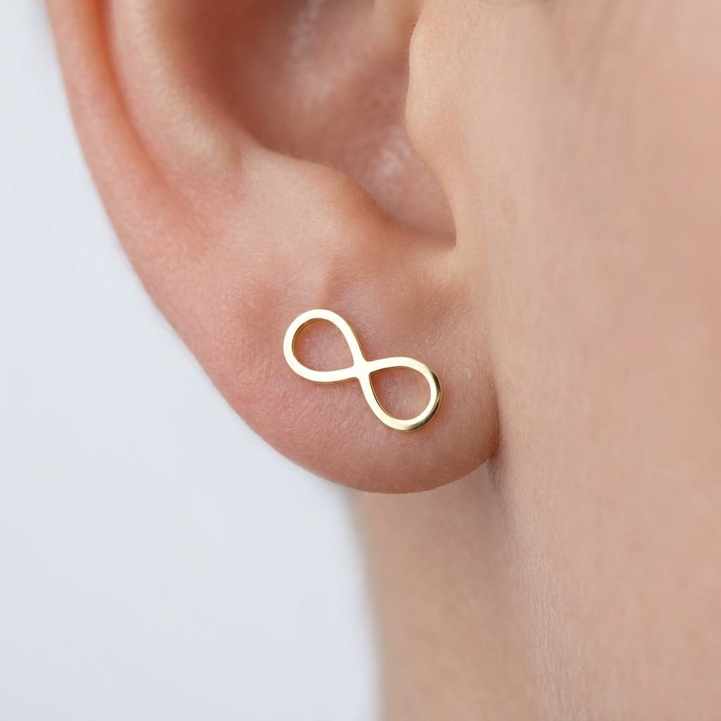 Pair of slim gold infinity symbol stud earrings on a white background. (2 of 9)