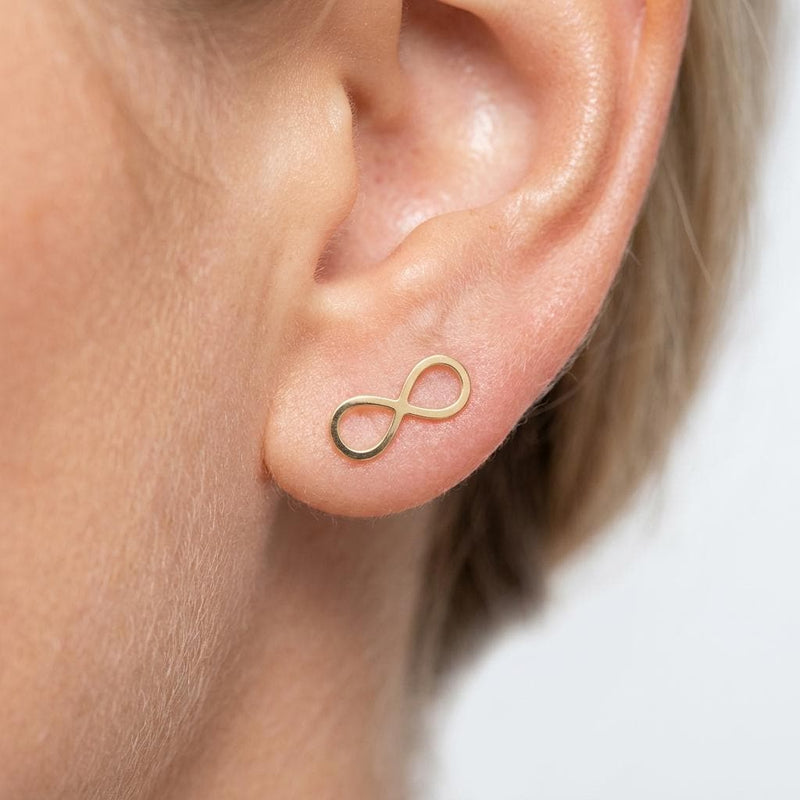 Pair of slim gold infinity symbol stud earrings on a white background. (3 of 9)