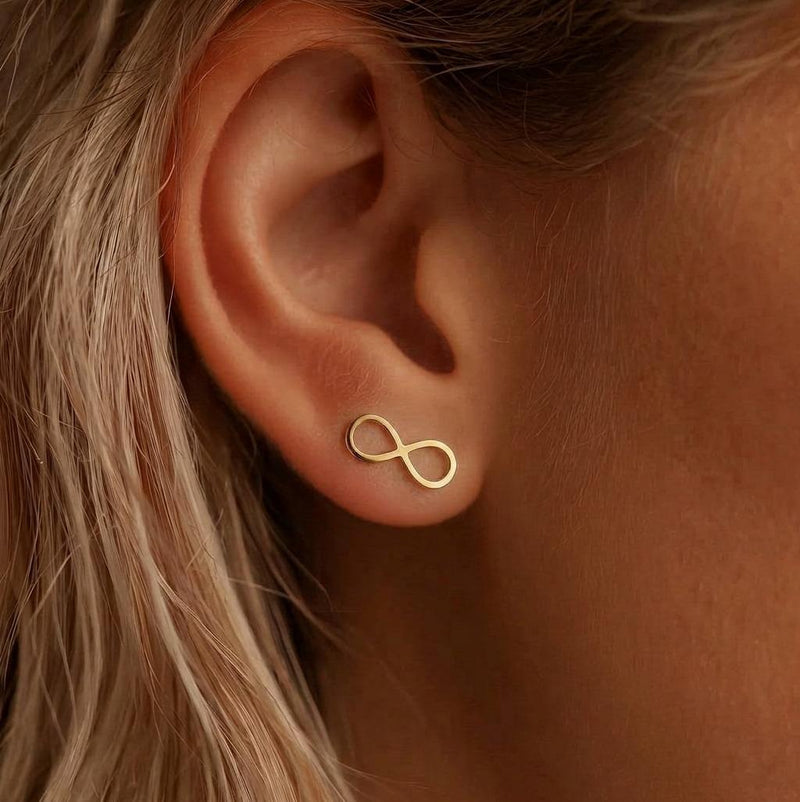 Pair of slim gold infinity symbol stud earrings on a white background. (6 of 9)