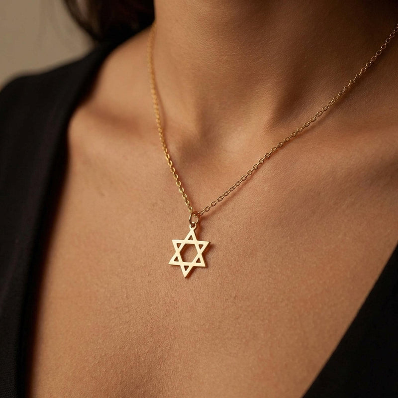 Small Star of David pendant in gold on a fine cable chain, shown on a plain background. (3 of 8)